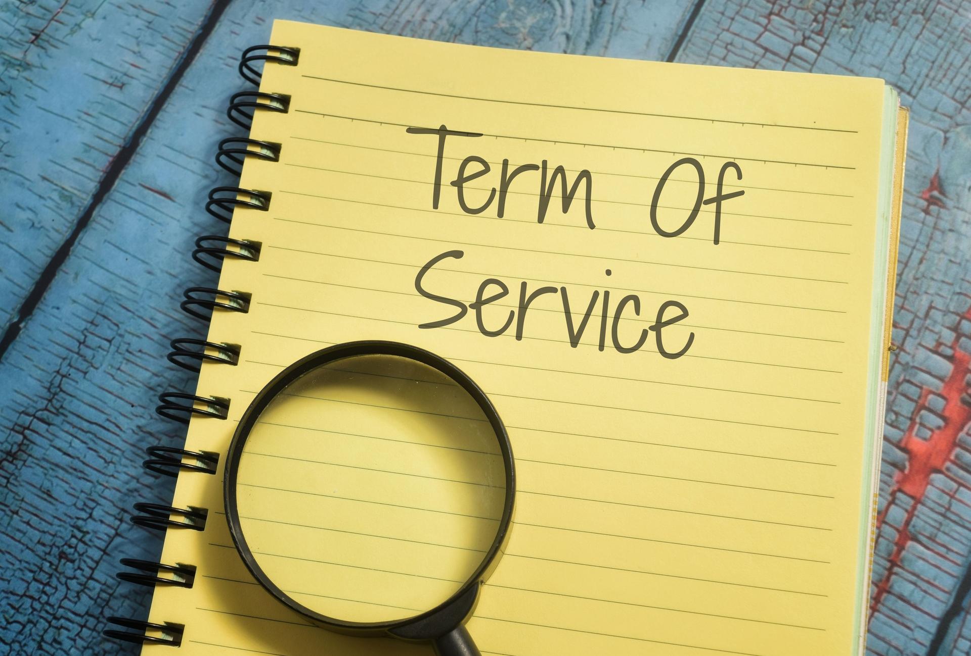 Closeup shot of a yellow notebook page with the writing term of service
