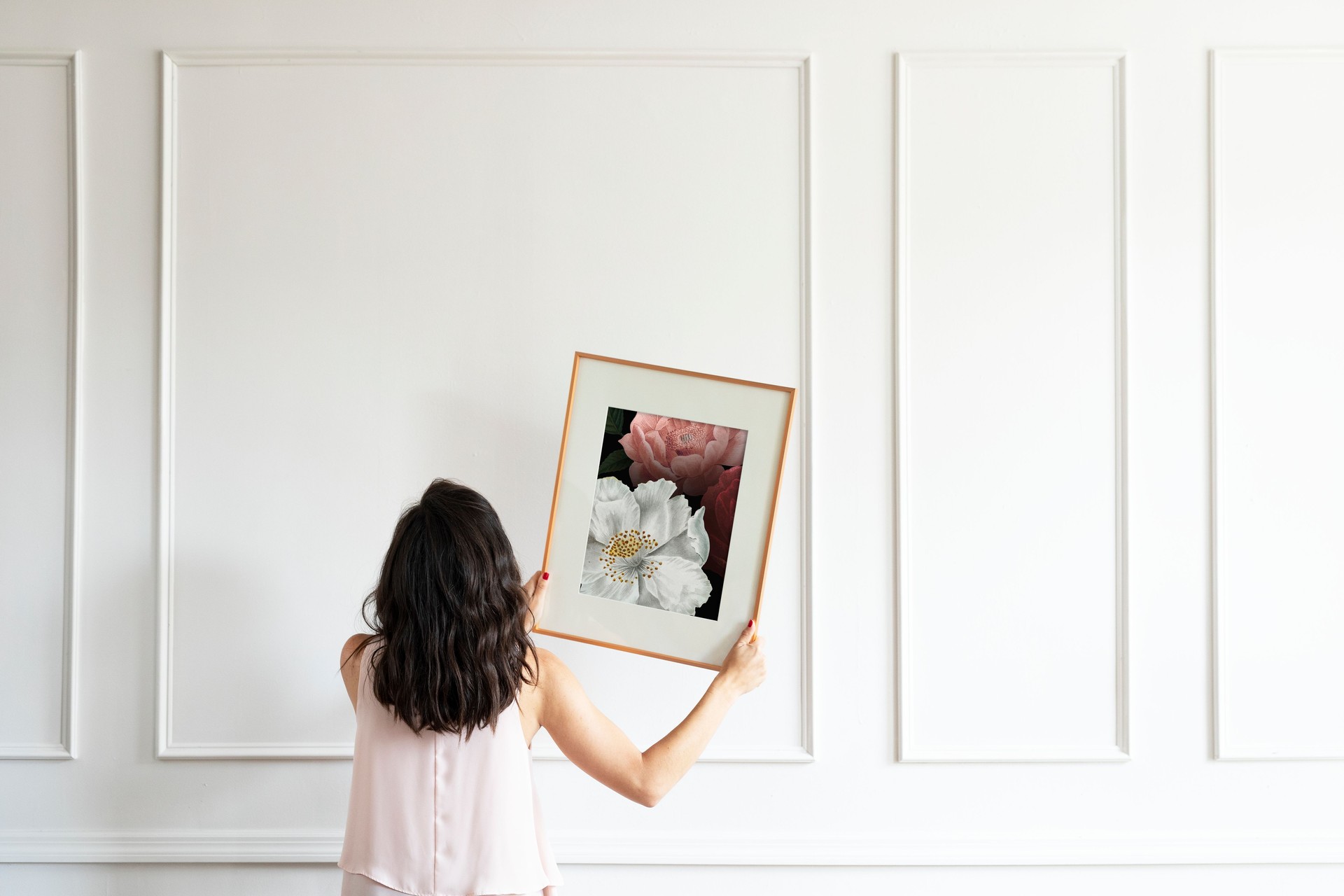 Curator hanging floral art frame on the wall